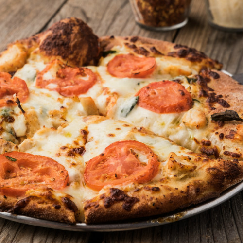 Personal pizza with tomatoes and cheese on top